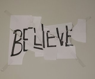 Team's homemade Believe motivational poster, torn and taped back together