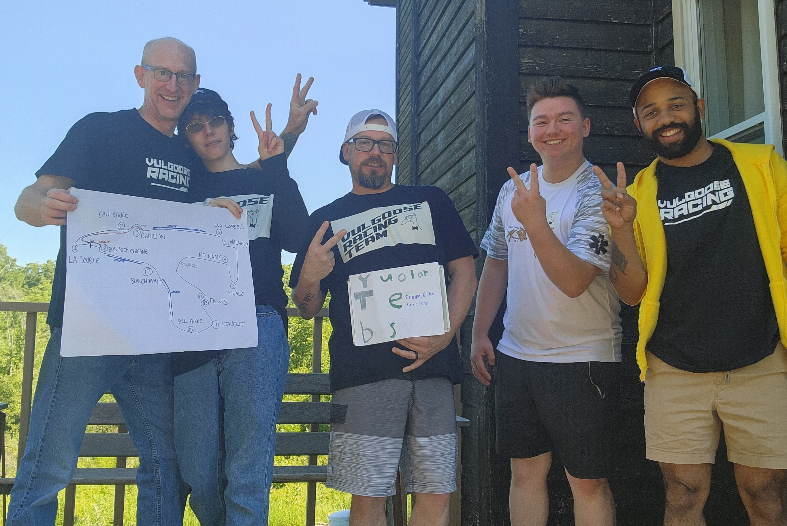 Vulgoose Racing team celebrating together at the 24 Hours of Spa, holding a hand-drawn track map